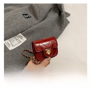 Detail of red quilted mini bag featuring golden camellia clasp and chain strap