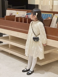 Kid's quilted crossbody bag styled with embroidered white dress and Mary Jane shoes