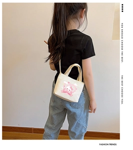 Kids mini canvas crossbody bag with cartoon bear and heart print on a child model
