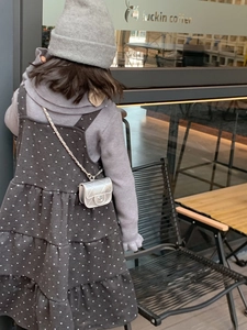 Detail shot of a silver quilted chain mini bag on a child's winter outfit lifestyle setting