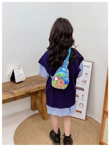 Blue kids crossbody bag with cartoon Capybara print shown in a rear view lifestyle setting