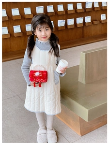 Close-up of red festive kids' handbag with pearl handle and white faux fur trim