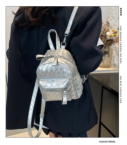 Detail of silver woven mini backpack with metallic texture and adjustable thin straps