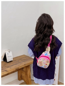 Kid back view showing adjustable pink strap and colorful cartoon bear printed chest bag