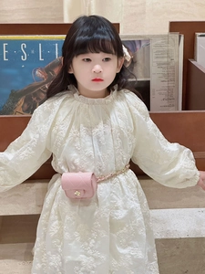 Detailed shot of white floral embroidery dress and pink quilted mini chain bag for girls