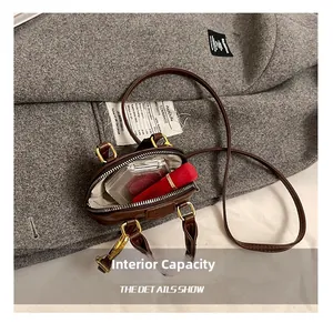 Detail of mini brown leather shell bag showing internal capacity for lipstick and compact