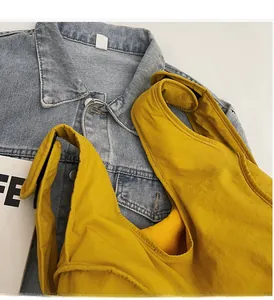 Flat lay detail of a bright yellow fabric backpack featuring white decorative text and straps