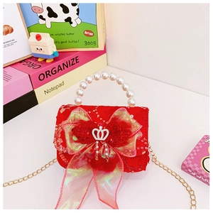 Detailed close-up of red sequin girls purse with pearl handle and iridescent bow