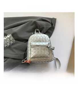 Close-up of silver mini backpack featuring intricate woven texture and metallic finish