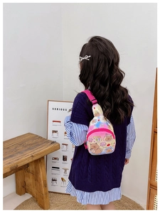 Detail of a kids crossbody chest bag with cute cartoon prints and adjustable pink strap