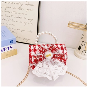 Detail of red tweed girl bag with pearl handle, bow decoration and golden chain strap