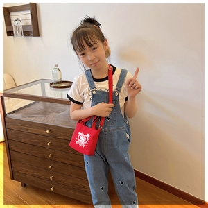 Toddler red canvas crossbody bag with cute bear and heart print shown on a model outfit