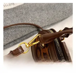 Close-up of high-quality gold metal hooks and brown leopard print leather details