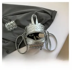 Top view of silver metallic woven mini backpack showing interior capacity for cosmetics