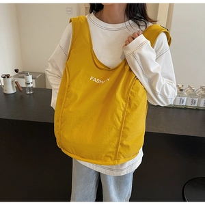 Close-up of bright yellow canvas tote bag with white FASHION print for casual daily use
