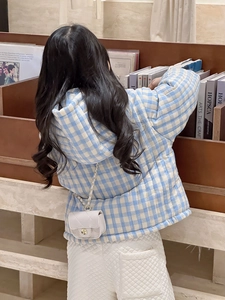 Close-up of quilted chain bag and blue checkered padded jacket for kids