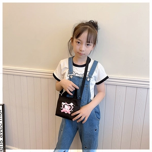 Detailed view of child's black canvas crossbody bag with pink heart and bear print