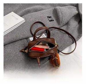 Mini brown PU bowling bag interior showing capacity for small cosmetics and gold zipper