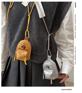 Close-up of stylish mini earphone coin purses in yellow and silver with adjustable straps