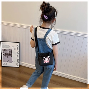 Close-up of Hello Kitty print and pink heart ribbon detail on a black canvas toddler bag