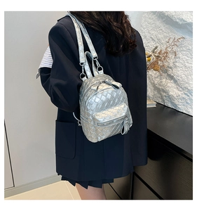 Detail of silver woven mini backpack with metallic leather texture on a model