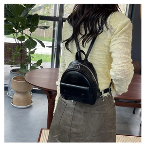 Detailansicht eines schwarzen Mini-Rucksacks aus Kunstleder mit silbernen Reißverschlüssen