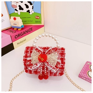 Detail of red tweed girl bag featuring pearl handle, gold bow, and metallic chain strap