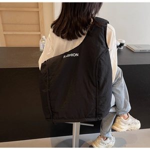 Macro shot of lightweight quilted nylon material and fashion text on the black backpack