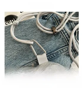 Detail of silver mini pouch with metallic texture and drawstring hook for accessories