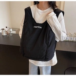 Detail of black quilted puffer tote bag with white fashion lettering in daily scene