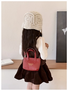 Détail du sac panier rouge en cuir PU pour filles avec logo doré et bandoulière