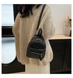 Model view of a mini black woven leather backpack with stylish intrecciato pattern