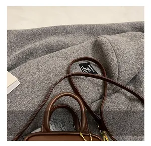 Detailed close-up of brown leather handbag interior with brand tag and carry handles