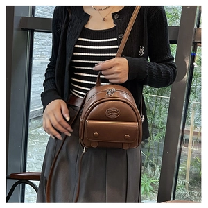 Detailansicht des braunen Mini-Rucksacks aus PU-Leder mit Logo und silbernem Verschluss