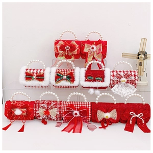 Detail of red festive girl's handbag with white pearls and Merry Christmas bow accents