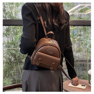 Brown vintage mini backpack for women showing real-life wearing size and fit in a park