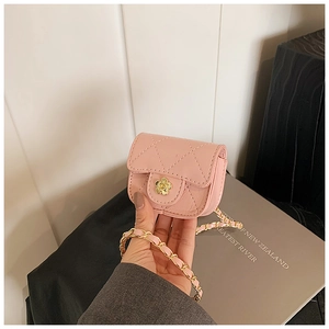 Detail of pink quilted mini bag with gold camellia clasp and chain strap for children