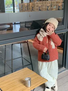 Détail montrant un mini sac à main mignon pour fille assorti à une tenue d'automne