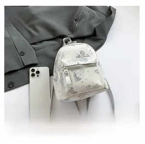 Draufsicht auf den weißen Mini-Rucksack mit Schmetterlingsdruck und Silberreißverschluss