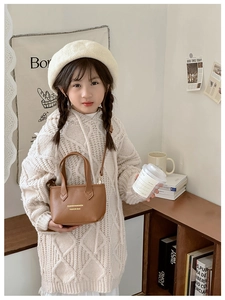 Sac seau en cuir marron porté par une petite fille dans un décor intérieur doux