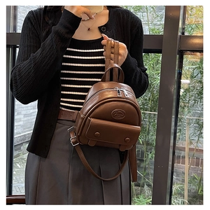 Nahaufnahme brauner Mini-Rucksack aus Kunstleder mit ovalem Logo und Trägern
