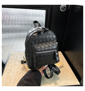 Detail of black woven synthetic leather mini backpack with metal zipper and top handle