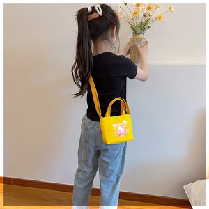 Detail of yellow canvas kids bag with cute cartoon bear print and adjustable strap