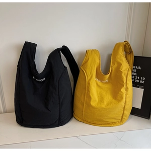 Detail view of stylish yellow and black nylon tote bags with Fashion letter print