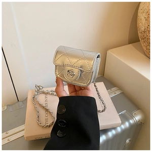 Macro shot of silver quilted mini bag featuring a camellia buckle and woven chain strap