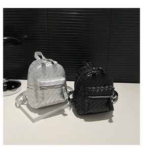 Detailed view of woven leather mini backpacks in silver and black with dual zippers