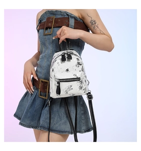 Detail eines weißen Mini-Rucksacks mit Stern- und Schmetterlingsdruck und Lederriemen