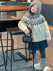 Detail of a black embossed logo mini bag paired with a winter knit outfit in a cafe