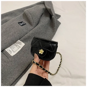 Detail of a black quilted mini bag featuring a gold camellia flower metal clasp closure