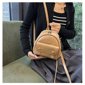 Detail of khaki mini backpack featuring Fashion embossed text and leather texture